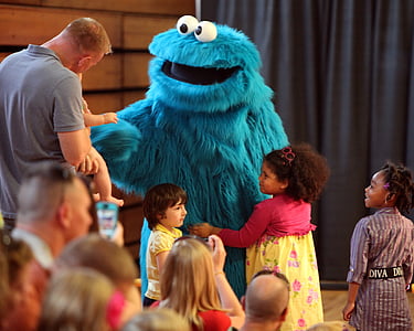children standing around Cookie Monster mascot thumbnail