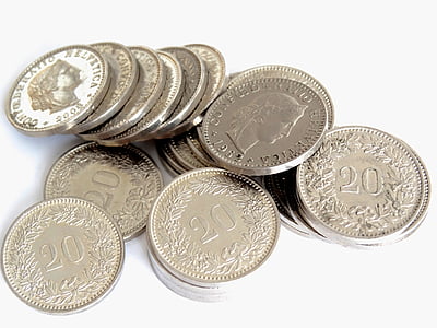 round silver-colored coins piled up on white surface thumbnail