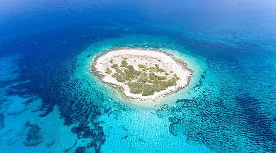 Aerial View Photography of Islet Surround by Body of Water thumbnail