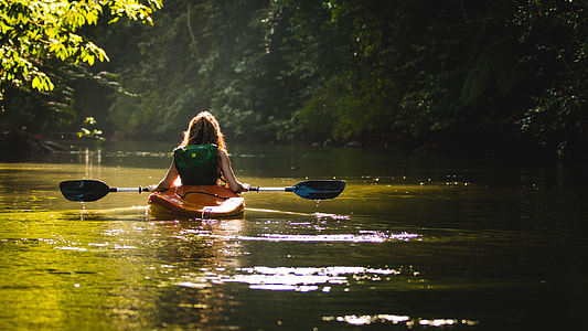 woman riding sit-in kayak on river thumbnail