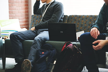 men wearing black sweater beside laptop during daytime thumbnail