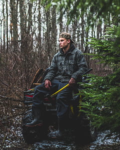 man holding yellow stick riding in front of yellow and black ATV under shade of trees at daytime thumbnail