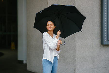 Woman in White Button-up Long-sleeved Shirt Holding Black Umbrella thumbnail