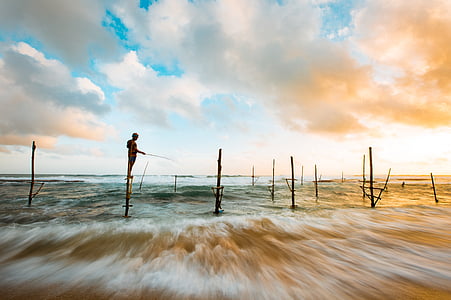 time lapse photo of kid fishing on seashore during daytime thumbnail