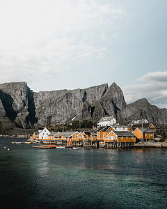 houses near mountains surrounded of body of water thumbnail