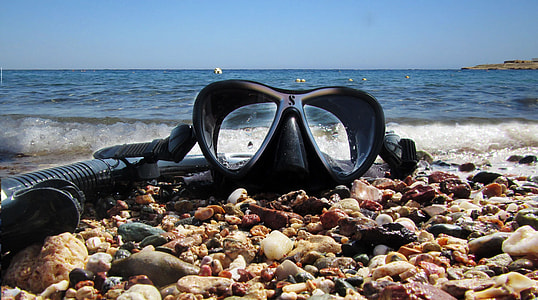 black swimming goggles on seashore thumbnail