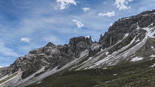 landscape photography of rocky mountain under cloudy sky during daytime thumbnail