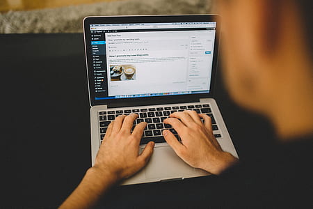 man wearing black top using MacBook Pro thumbnail