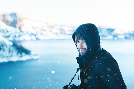 man looking at the camera while snow is falling thumbnail