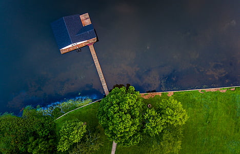 aerial photography of black and brown house surrounded by body of water thumbnail