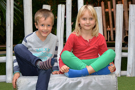 boy and girl sitting near fence on focus photo thumbnail