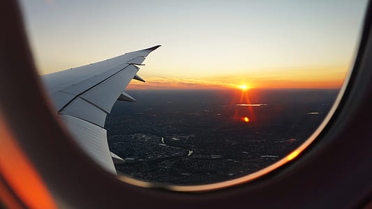 person's airplane window view of clear skies above city thumbnail