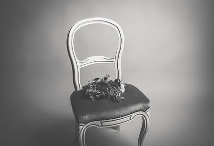 grayscale photo of floral wreath on chair thumbnail