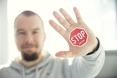 Photography of a Persons Hand With Stop Signage thumbnail