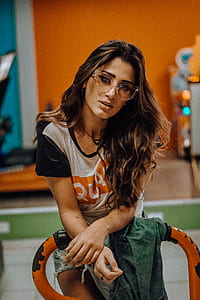 woman leaning on orange metal bar inside room thumbnail