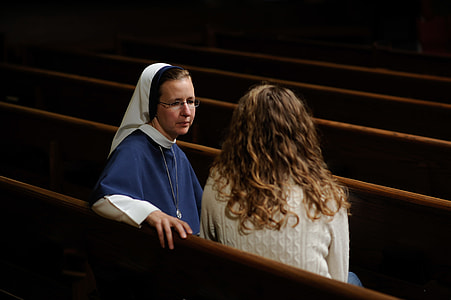 woman wearing white shirt sitting beside nun in church thumbnail