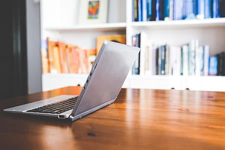 silver and black laptop on brown wooden table thumbnail