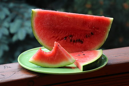 person showing sliced watermelons on green ceramic plate thumbnail