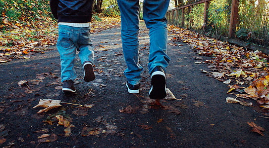 two people waling on road with dried leaves thumbnail