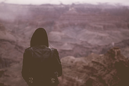 selective focus photography person in black hoodie on top of mountain thumbnail