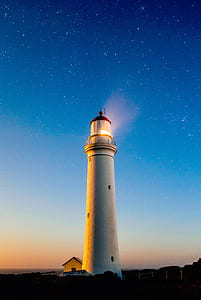 white lighthouse under starry night thumbnail