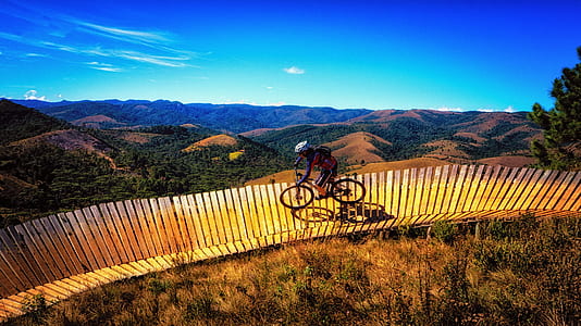 man riding black bicycle on brown wooden surface thumbnail