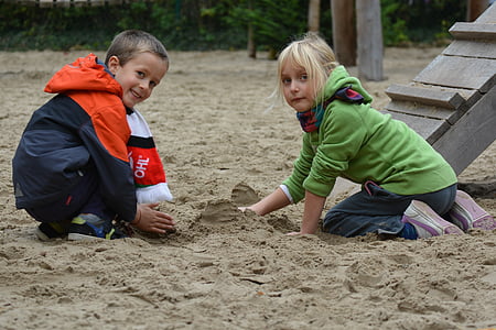 boy and girl playing on sand outdoors during daytime thumbnail