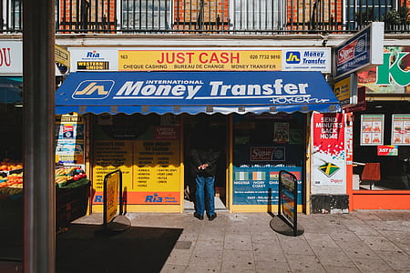 person standing below blue and white awning in front of store thumbnail