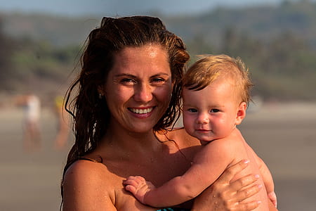 shallow focus photography of woman carrying boy during daytime thumbnail