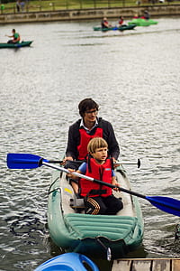 man and boy riding inflatable boat on body of water thumbnail