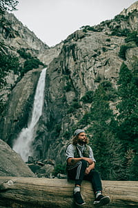 man sitting on tree log thumbnail