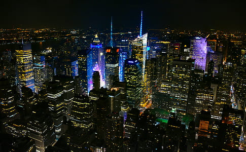 buildings with lights turned on at nighttime thumbnail