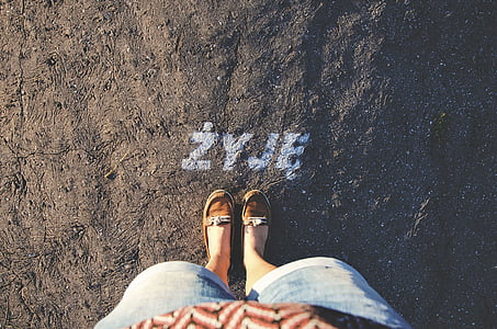 person standing near zyje written on concrete floor thumbnail