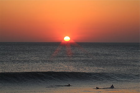 silhouette of people in water during golden hour thumbnail