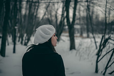 woman in black coat in the middle of the woods thumbnail