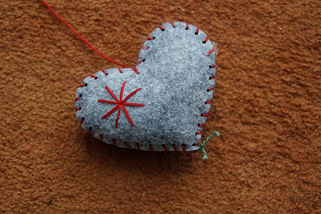 gray heart-themed pincushion on brown textile thumbnail
