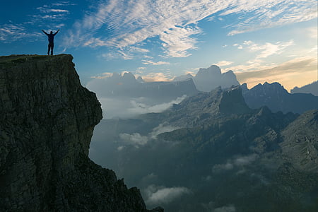 silhouette photo of person on cliff during daytime thumbnail