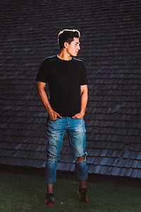 man tacking its hand on jeans pocket looking sideways thumbnail