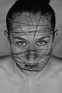 grayscale photo of woman's face covered with black thread thumbnail