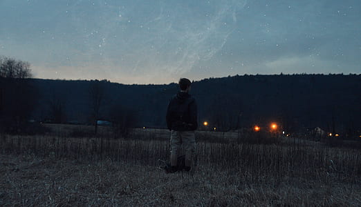 man standing near mountain during starry night thumbnail