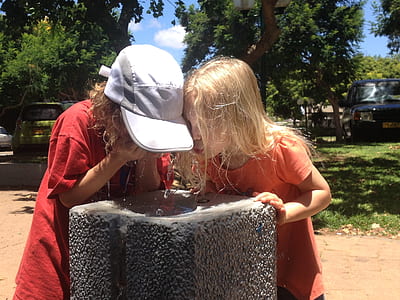 two girls washing face on gray water fountain thumbnail