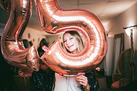 woman holding 25-shaped balloons thumbnail