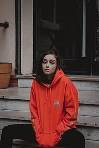 woman in red pullover hoodie sitting on stairs thumbnail