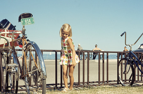 girl standing in between bicycle on seashore thumbnail