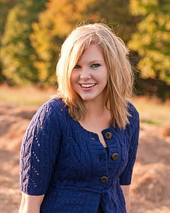 selective focus photography of woman wearing knitted short-sleeved button-up coat taking photo near trees at daytime thumbnail