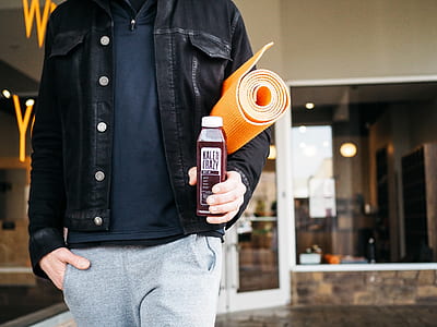 person in leather jacket holding plastic bottle thumbnail