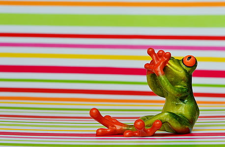 green and red frog holding mouth figurine thumbnail
