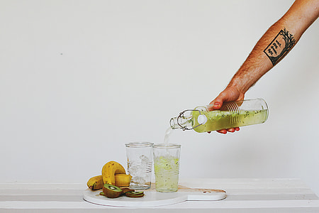 person holding clear glass bottle thumbnail