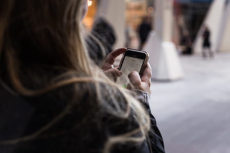 woman holding post-2016 iPhone and brown case thumbnail