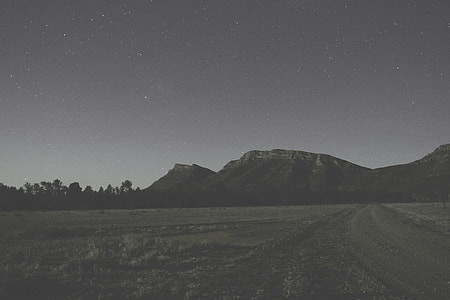 grayscale photography of mountains and grass field thumbnail